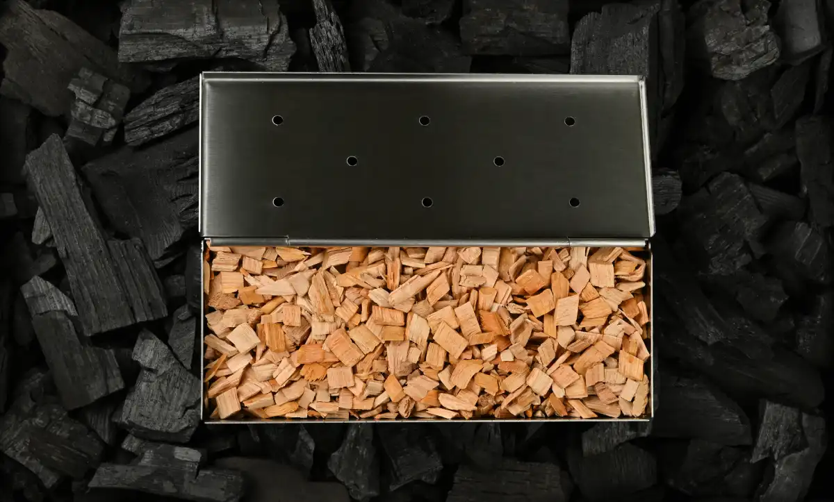 Eine offene Schachtel Holz auf Holzkohle in einem Smoker
